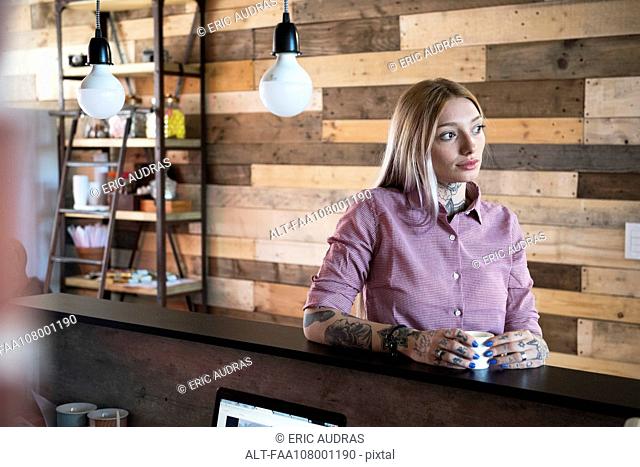 Young woman relaxing at counter in coffee shop