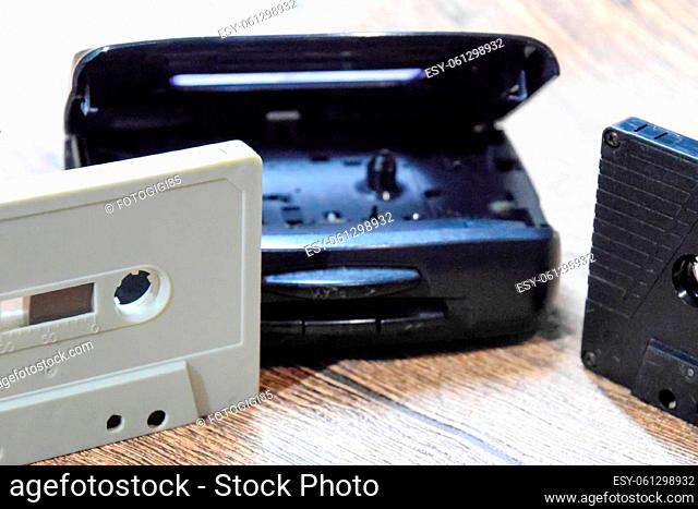 Audio cassette. Retro music medium, compact cassette for tape recorder. Retro audio cassettes next to a portable player to play compact cassettes