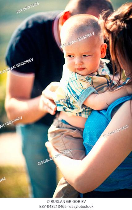 Happy family with baby son on nature background