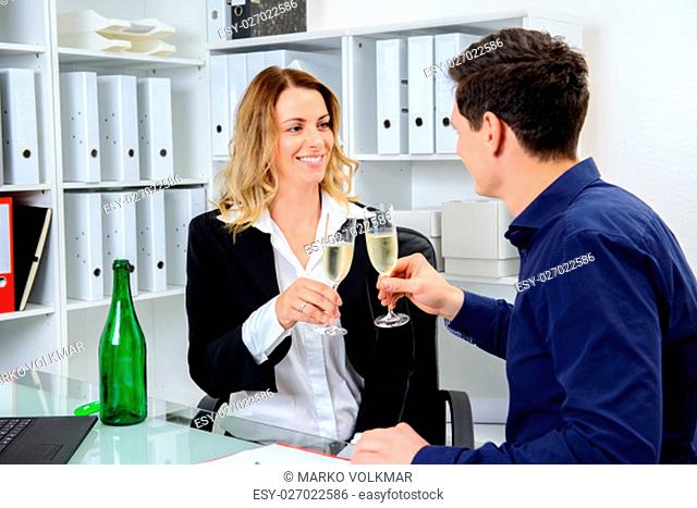 young businessman and businesswoman celebrating together in the office