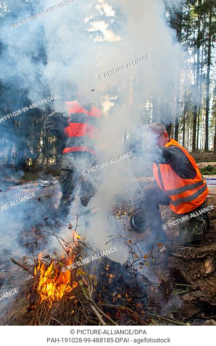 28 October 2019, Saxony-Anhalt, Straßberg: Soldiers of the Logistics Battalion 171 from Burg burn the bark of the spruces infested by the bark beetle on a...