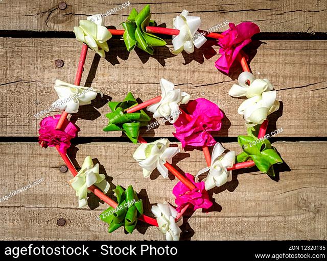 Traditional polynesian flower necklace on a wooden background