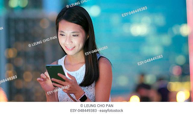 Woman use of cellphone at outdoor city at night