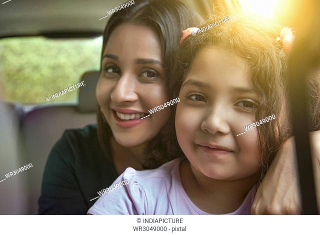 Portrait of mother and daughter traveling in a car