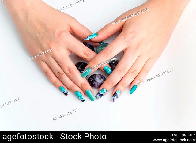 Closeup of woman nails with creative purple and green manicure. Fluorinit print. Copy space