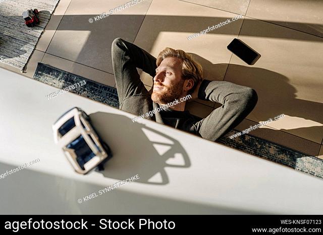 Relaxed man lying on the floor at home
