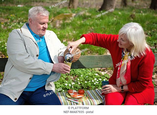 Senior couple eating in park