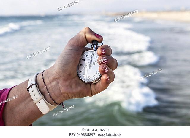 analog Stopwatch in hand with sea in the background