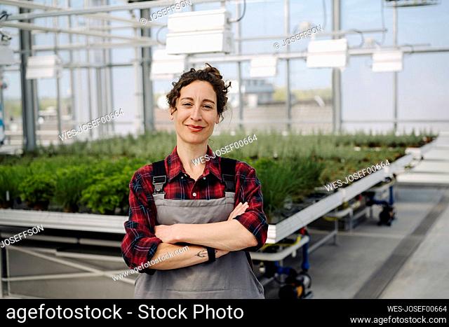 Portrait of confident woman in greenhouse of a gardening shop