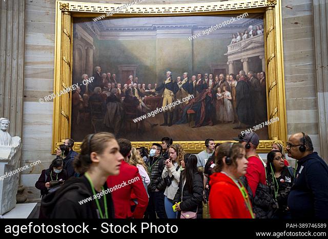 Tourists stand under a painting €œGeneral George Washington Resigning His Commission€ in the US Capitol Rotunda. 19 people in this painting have been...