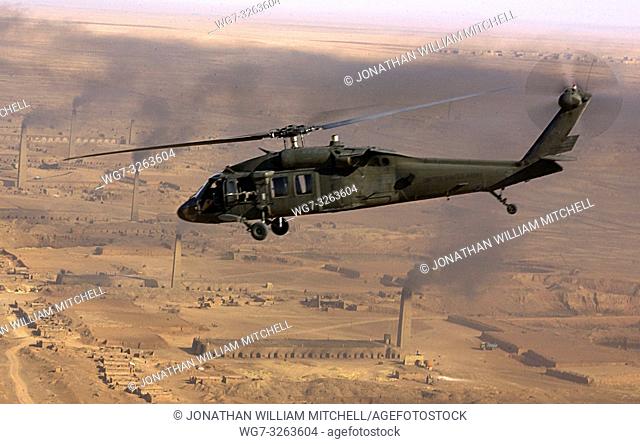 IRAQ Baghdad -- 06 Nov 2003 -- A UH-60 Blackhawk helicopter passes smoke from factories below, East of Baghdad, Iraq. US Air Force Photo (released) -- Picture...