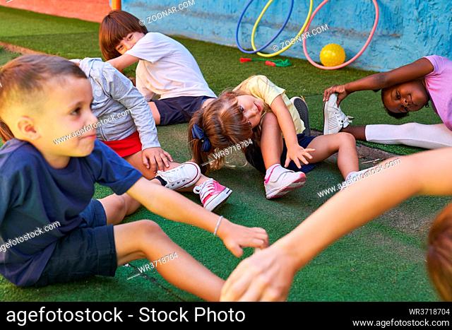Gruppe Kinder gemeinsam beim Kinderturnen mit Erzieherin in der Kita