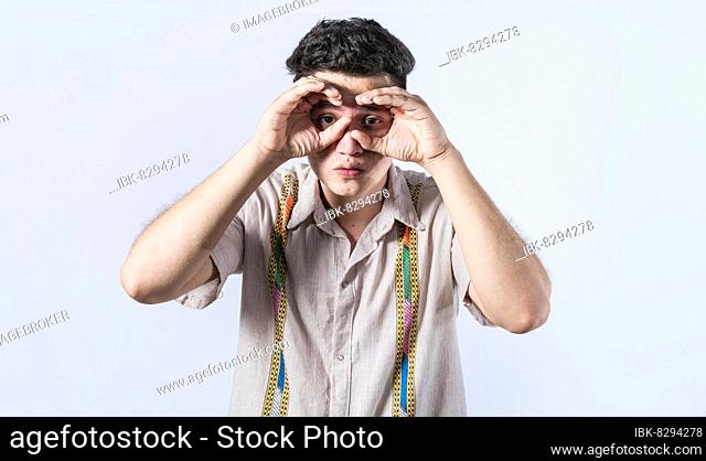 Man making binoculars gesture, Curious man making binoculars gesture, Guy on isolated background making binoculars gesture, man using his fists as binoculars