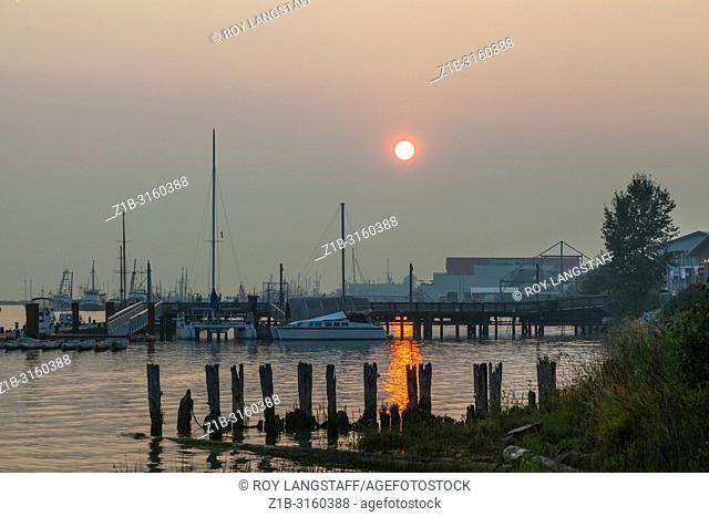 Evening sun struggling to penetrate the forest fire smoke over Steveston, British Columbia