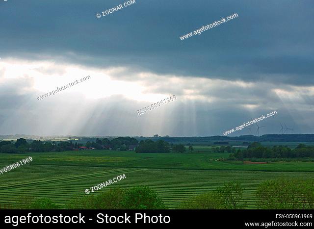 Beautiful countryside and sunrays passing through clouds on landscape with fields near Kiel - Schleswig-Holstein - Germany