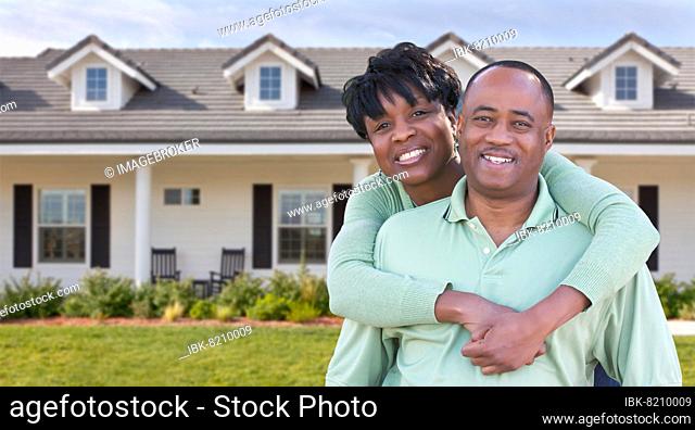 Happy african american couple in front of beautiful house