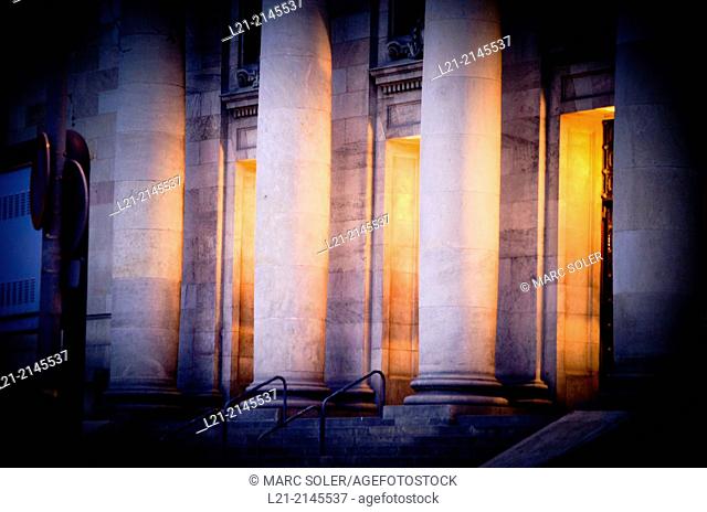 Columns and interior light at dusk, night. View of central post office building designed by Josep Goday Casals and Jaume Torres Grau