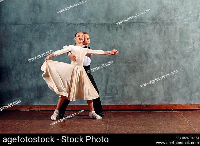 Young boy and girl dancers dances at ballroom dance Viennese Waltz