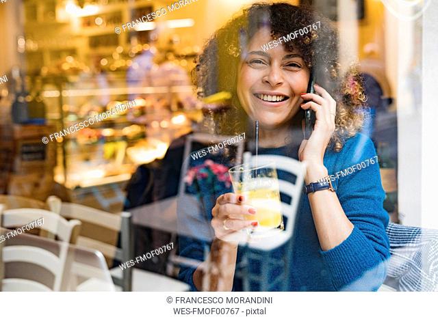 Portrait of happy woman on the phone in a cafe