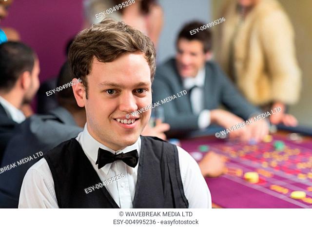 Dealer standing at roulette table in casino