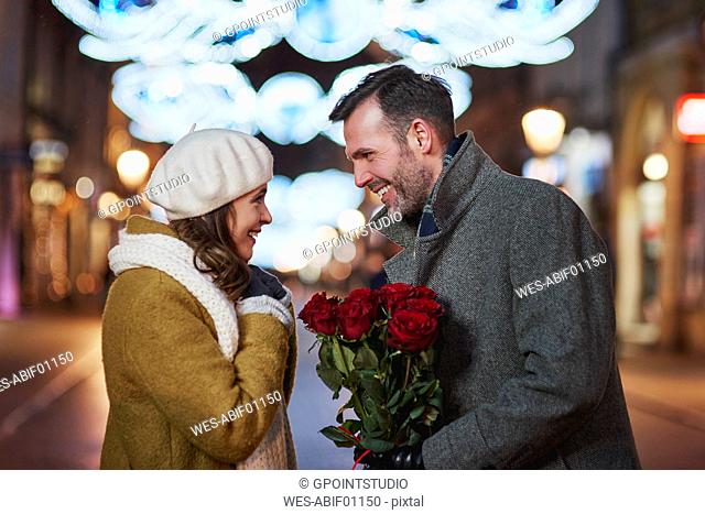 Man gifting his girlfriend bunch of red roses on Valentine's Day