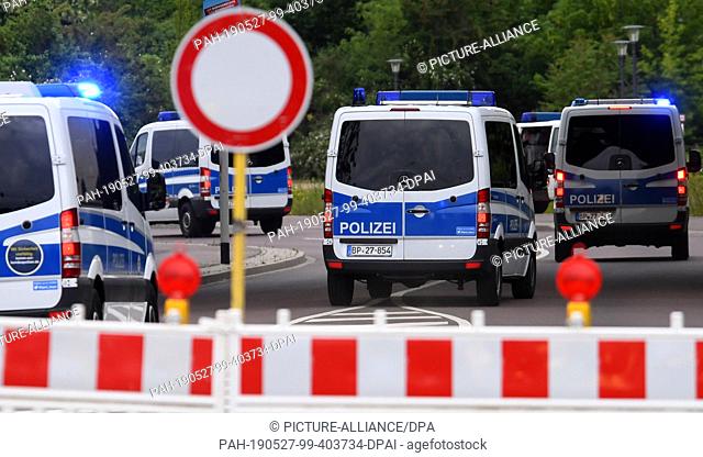 27 May 2019, Saxony-Anhalt, Halle (Saale): A column of police vehicles drives into the evacuation area of a bomb find in Halle/Saale