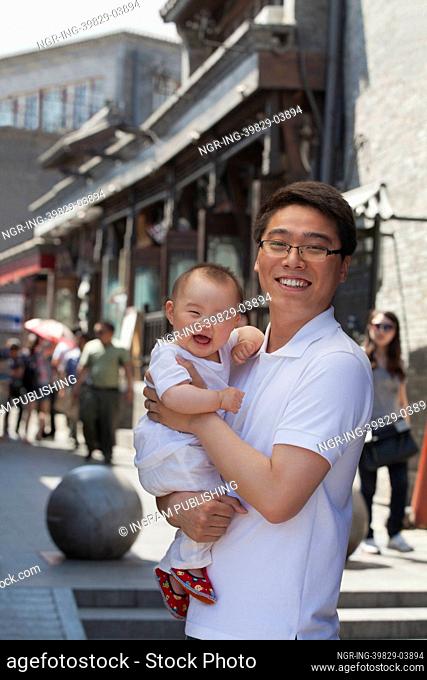 Portrait of father holding his baby son, outdoors Beijing
