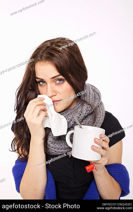 A beautiful young woman, lady, girl, cold, runny nose, headache, tissues, paper hankies, cup of tea, scarf  (CTK Photo/Rene Fluger) MODEL RELEASED, MR