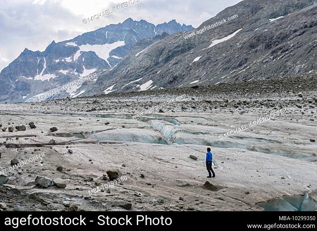 Switzerland, Valais, Haute Route Chamonix Zermatt, mountain guide explores the route over the Glacier d'Otemma on a cloudy day