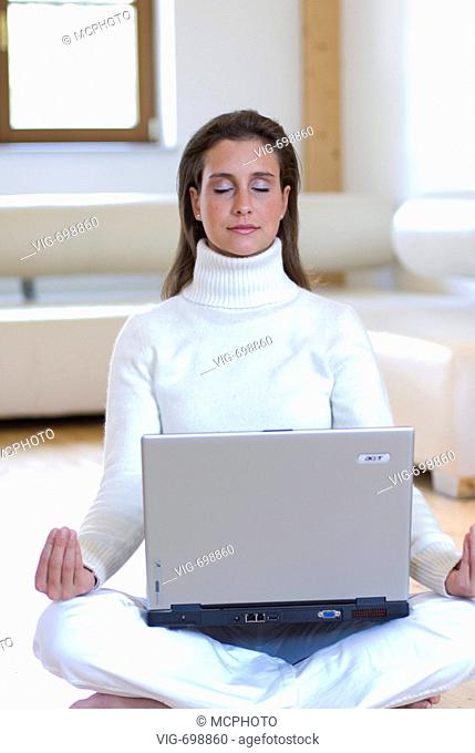 young woman practising yoga with a notebook on her lap  - 18/12/2007