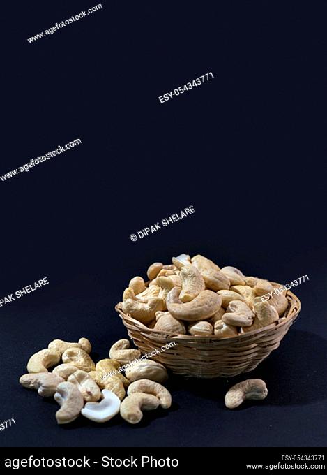 Cashew nuts in basket on black background