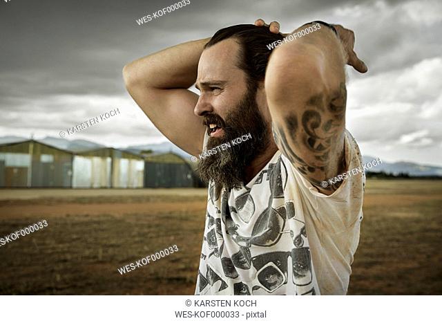 Man with full beard in abandoned landscape