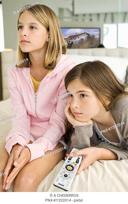Two girls watching television