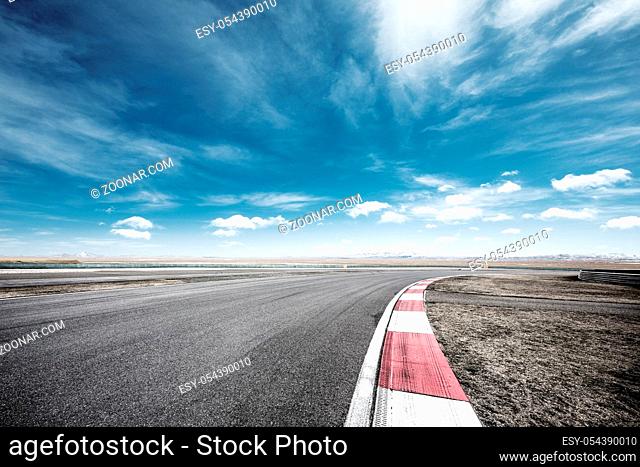 empty asphalt road and snow mountains in blue cloud sky
