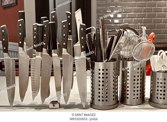 Knives on magnetic rack in commercial kitchen