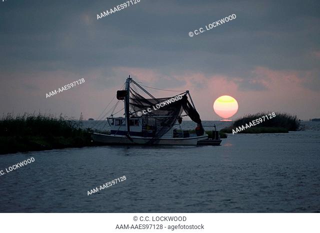 A shrimper anchors for the night west of the Mississippi Delta as the sun sets. They are shrimping in one of the few areas open due to the deepwater horizon oil...
