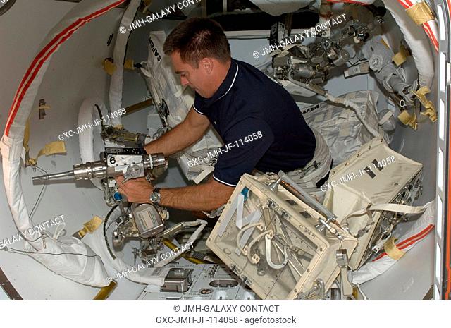 Astronaut Christopher Cassidy, STS-127 mission specialist, works with extravehicular activity (EVA) tools in the Quest airlock of the International Space...
