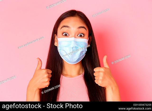 Covid-19 pandemic, coronavirus and social distancing concept. Close-up of excited and amazed pretty asian girl support great idea