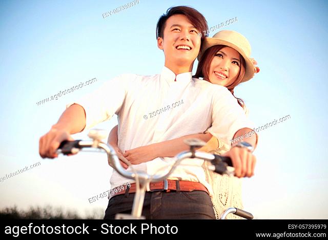 The young couple riding a bicycle high quality photo