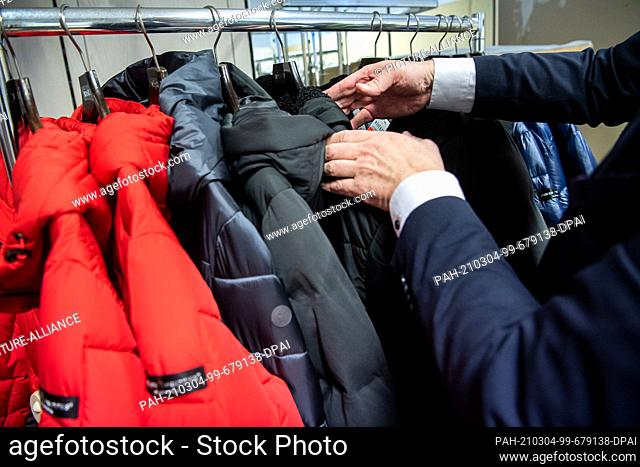 02 March 2021, Bremen: Winter clothing is sorted in a fashion store's warehouse. Spring is coming, but fashion and shoe stores up north are still sitting on the...