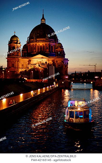 The illuminated Berlin Cathedral and a tour ship are pictured from the Town Hall Bridge above the Spree river in the evening of 24 August 2013 in Berlin