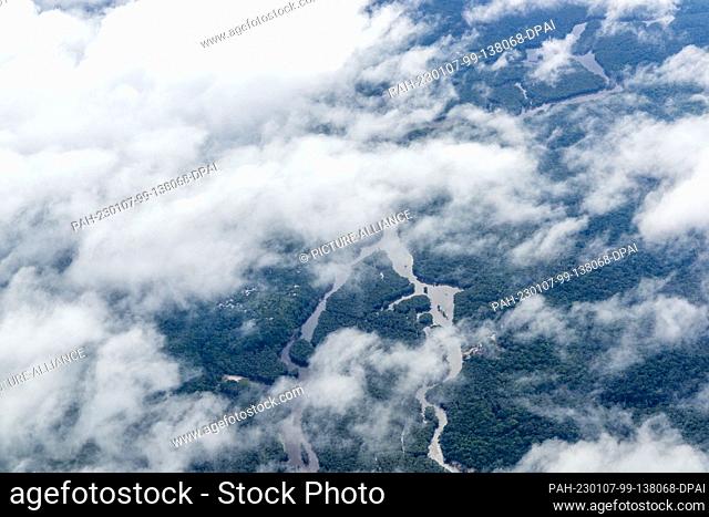 02 January 2023, Brazil, Manaus: Clouds pass over the Amazon rainforest, taken from a seaplane. The world's largest tropical rainforest is crisscrossed by...