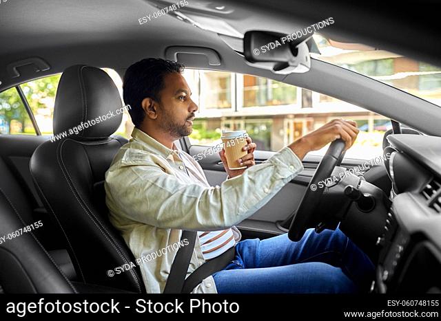 indian man or driver with coffee driving car