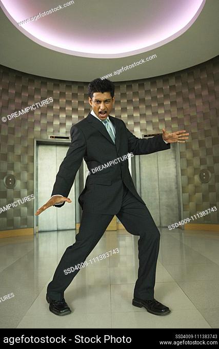 Playful Indian businessman in office lobby