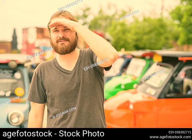 Portrait of young bearded tourist man having vacation in Ayutthaya, Thailand