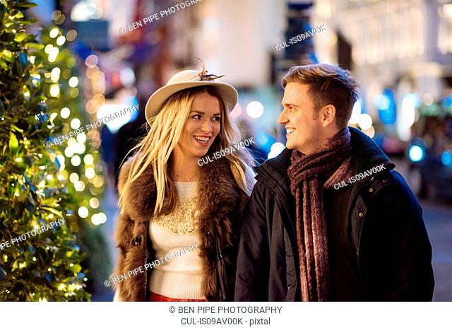 Romantic young couple strolling along New Bond street at xmas, London, UK