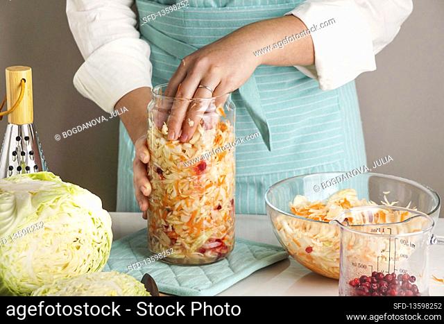Fermented cabbage being transfered to a glass jar