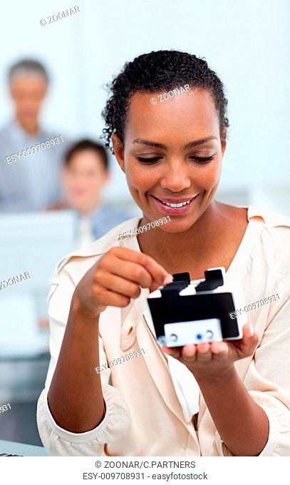 Smiling businesswoman consulting a business card holder