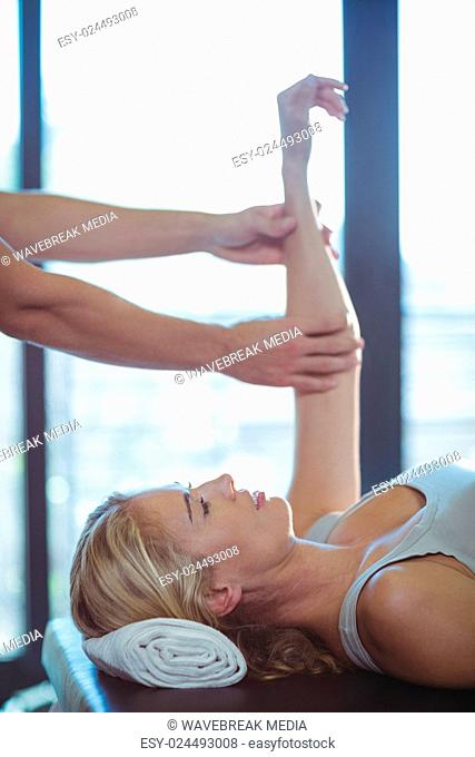Woman receiving hand therapy exercises from physiotherapist