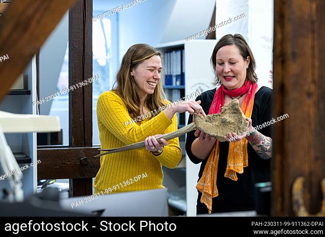 PRODUCTION - 10 March 2023, North Rhine-Westphalia, Soest: Archaeologist Julia Ricken (l) and finder Simone Grundmann look at the bones of a 15